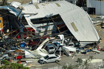 Automotive workshop destroyed by hurricane wind with damaged cars under ruins in Florida....