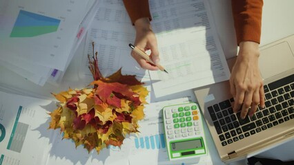 elegant 40 years old small business owner woman with autumn yellow leaves and cup of hot cocoa in the modern green office.
