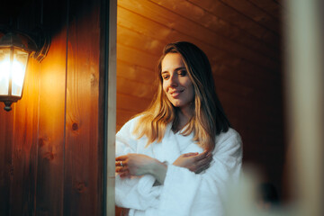 Fototapeta premium Happy Woman trying a Sauna Relaxing on Vacation. Beautiful girl enjoying wellness therapy in a hot house 