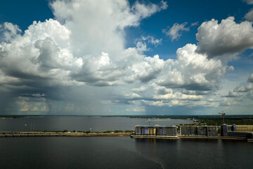 Tower lifting cranes at high residential apartment buildings construction site at seaside. Real estate development