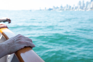Person with hands on the railing on a boat in Lake Ontario Canada