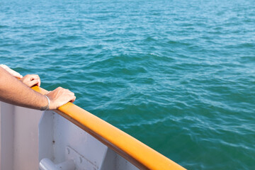 Fototapeta na wymiar Person with hands on the railing on a boat in Lake Ontario Canada