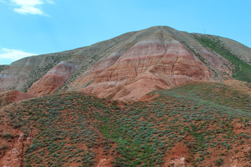 View of the bright red sandy-clayey slopes of the mountain Big Bogdo