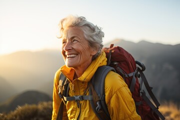 Smiling portrait of a happy senior woman hiker hiking in the forest and mountains - obrazy, fototapety, plakaty
