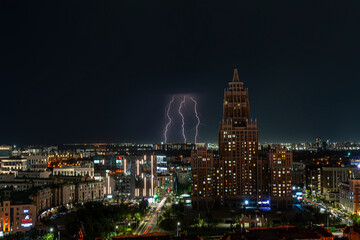 Fototapeta na wymiar Astana, Kazakhstan, August, 2023. Night view of the skyscraper of the central street of the capital during a thunderstorm with lightning.