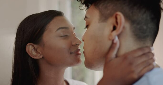 Face, man and woman kiss for love, care and intimate moment in relationship together at home. Couple, partner and kissing for romance, trust and loyalty on valentines day, anniversary and commitment