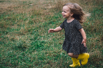 Mom and daughter play catch-up or bloopers in nature in a park or village. Active games with a child in the fresh air. The concept of a happy childhood. The girl runs merrily with her mouth open