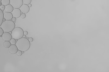 water and oil droplets to creating circle and bubble shape on grey greadient background.