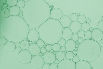 Oil and water bubbles pattern of an art image on pale green gradient background. 