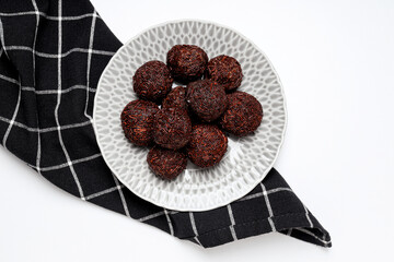 Brigadeiro on plate and towel on white background, top view