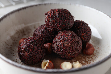 Brigadeiro and hazelnuts in white bowl, close up