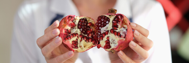 Female nutritionist show pomegranate as important source of vitamins, antioxidants and microelements