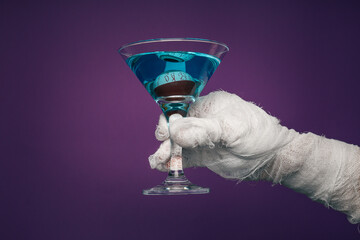 Hands wrapped in a bandage hold a cocktail