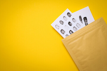 An envelope with fingerprints on a yellow background