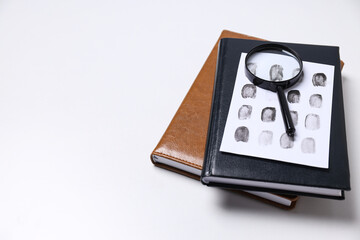 Books, magnifying glass with fingerprints on a white background