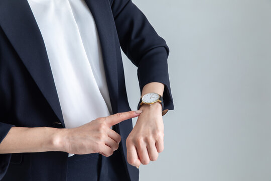 腕時計を見るスーツを着た女性　woman looking at watch