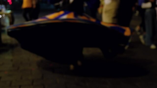Defocused footage of tanoura dancing on city street. National Egyptian dance tanoura. Whirling dance of egyptian dervishes