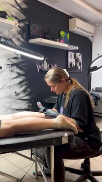 Tattoo artist makes a tattoo to a client