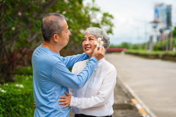 Obraz premium Elderly love, couple relaxing outdoors in blissful family time, peaceful moments, Mature asian husband and wife family time in natural serenity, heartwarming, relaxation