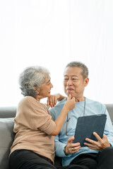 Blissful moments, elderly asian husband and wife sharing joy on sofa, timeless romance, heartwarming moments, peaceful harmony, timeless togetherness, happy family couple, grey hair