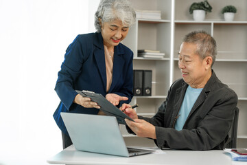 Asian senior man and woman collaborating in small medium enterprises working together. Couple...