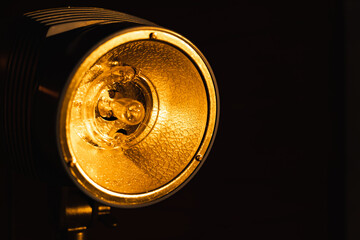 Studio flash light bulb closeup. Spotlight studio lamp on a black background. Photoelectric...