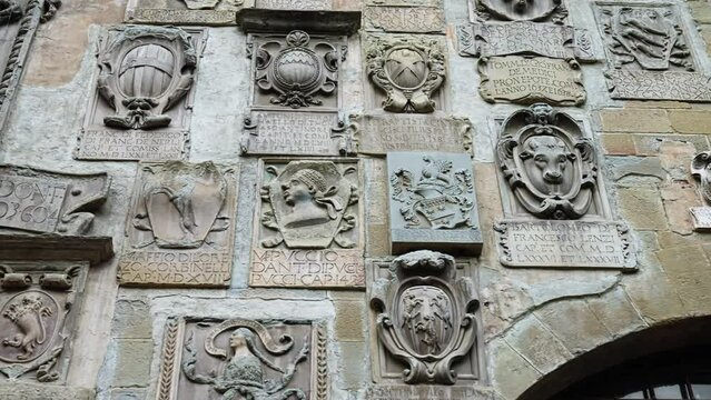 Stone Coats Of Arms On The Facade Of Pretorio Palace At Via dei Pileati In Tuscany, Italy. close-up