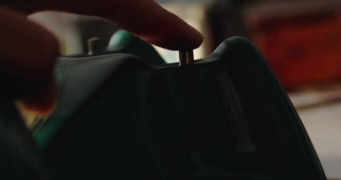 Close-up of a person's hand picking up the receiver of a dialer phone and trying to make a call.
