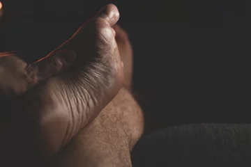 Rolgordijnen male feet in the dark. Close-up of man's bare feet © yavorovich