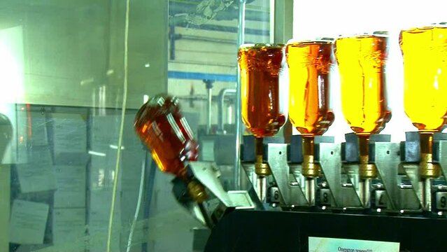 Whiskey and brandy production line. Factory machine pouring alcohol into bottles