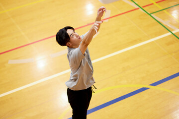 体育館でバスケットボールの練習をする日本人大学生の男性