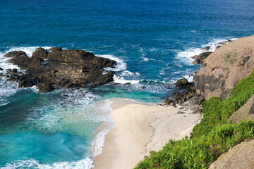 view of the beach and rocks from the top of the merese hill in Lombok, waves and rocks, waves on the beach, waves crashing on the rocks, coast of island, sea and rocks, beach and rocks