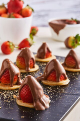 Mini Strawberry Pancake dip with chocolate served in dish isolated on background top view of cafe food