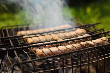 Meat sausages are grilled. Picnic in nature. Close-up. Selective focus. Copyspace