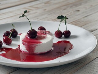 Food background.Ice cream with cherries on a white plate, poured with red jam.Side view.