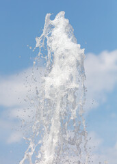 Fountain splashes against the blue sky. Background