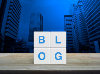 BLOG letter on white block cubes on wooden table over modern office city tower and skyscraper, Business communication concept