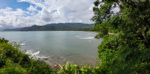 Coastal idyll, bay with tropical palm trees and golden sand in Costa Rica