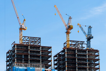Building construction site and cranes with the blue sky background