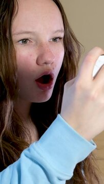girl holds phone horizontally she is very surprised, she opens mouth strongly looking at herself in reflection in mirror surprise to be interested in changes in appearance pimple on face