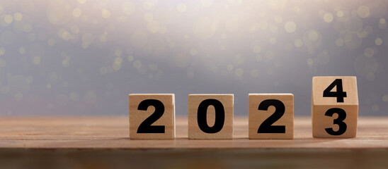 Happy new year 2024. Wooden calendar cubes change from 2023 to 2024. New year background with copy space
