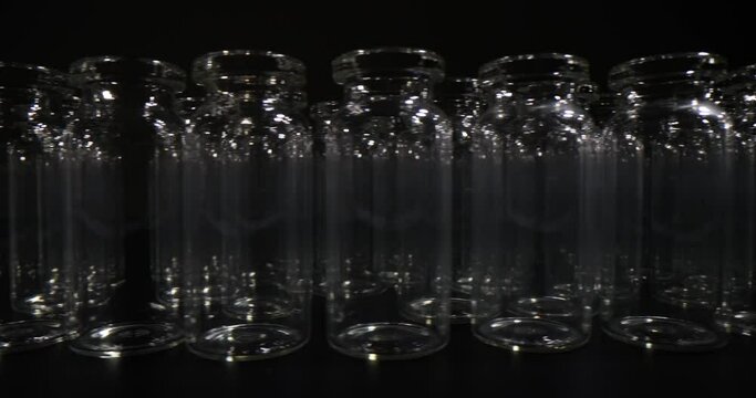 Empty glass vials in rows used for manufacture and packaging of vaccines. Medical glassware