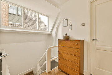 a small room with a wooden dresser and white painted walls in the room is very light, but it's not...