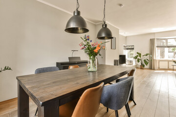 a dining table and chairs in a living room with white walls, hardwood flooring and light grey wooden floors