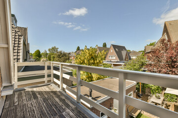 Fototapeta premium a balcony with some trees and houses in the background, as seen from an apartment's roof decking area