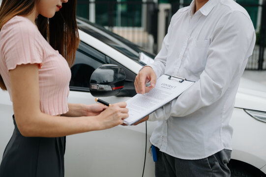 Customers And Car Insurance Agents Have Entered Into Agreements And Signed Documents To Claim Compensation After On The Road In Sun Light..