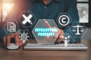 Intellectual property concept, Businessman hand touching Intellectual property icon on virtual screen.
