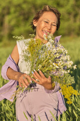 thoughtful, modern retiree immerses herself in the tranquility of summer meadow, the wildflowers in her hands serving as poignant reminder of life's continuous journey