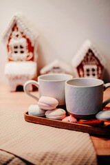 Two cups against the background of New Year's gingerbread houses New Year's hot drink. Christmas and New Year atmosphere.