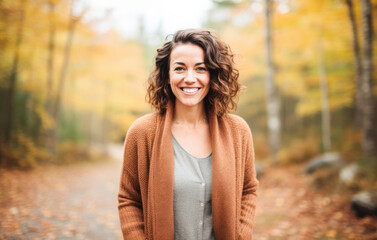 Portrait in the forest of a pleased 30 years old woman. Joyful woman in an  outdoor fall scenery having fun at the autumn season. 